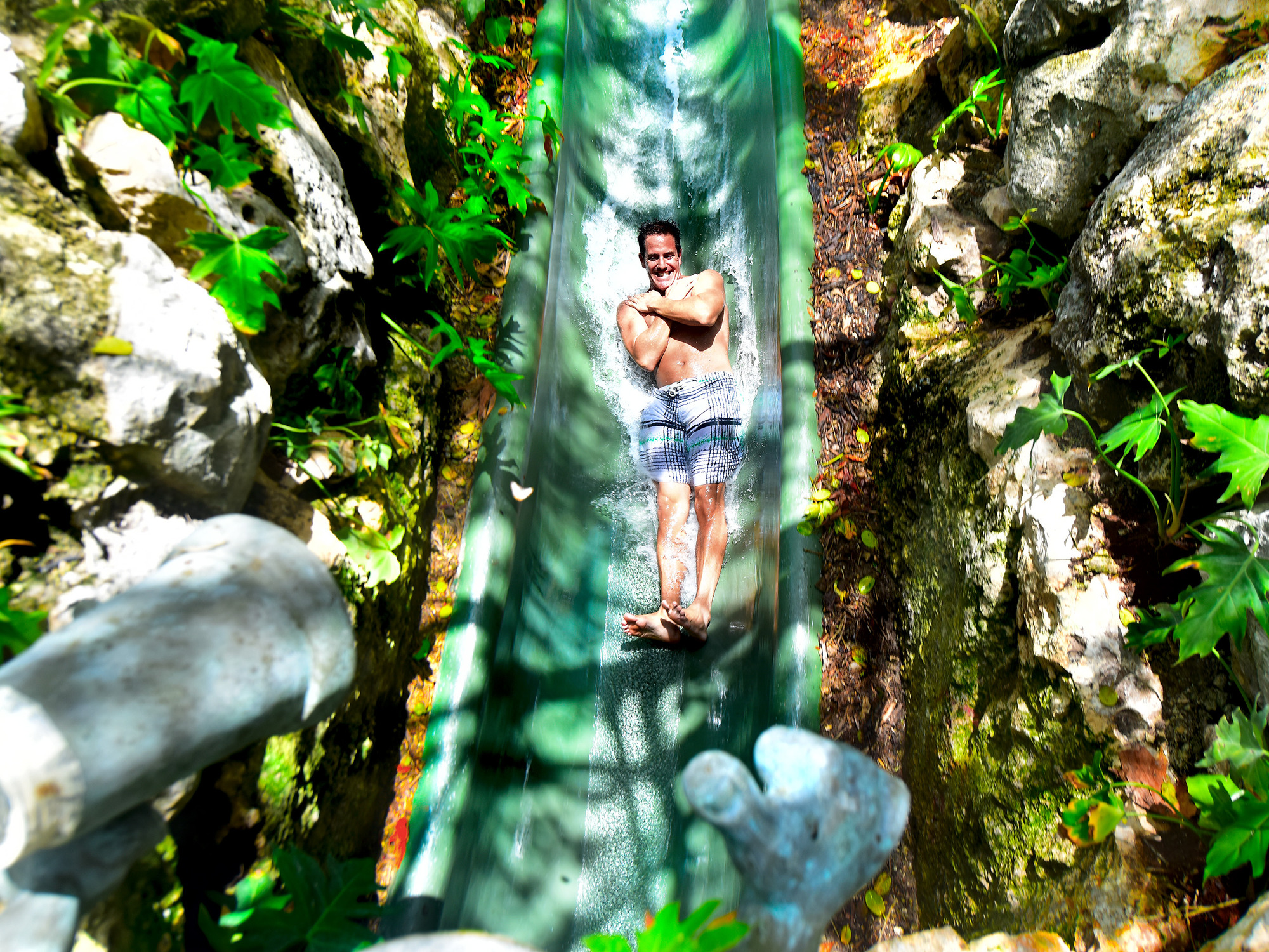 Young Man going down the water slide at Xenses Xcaret
