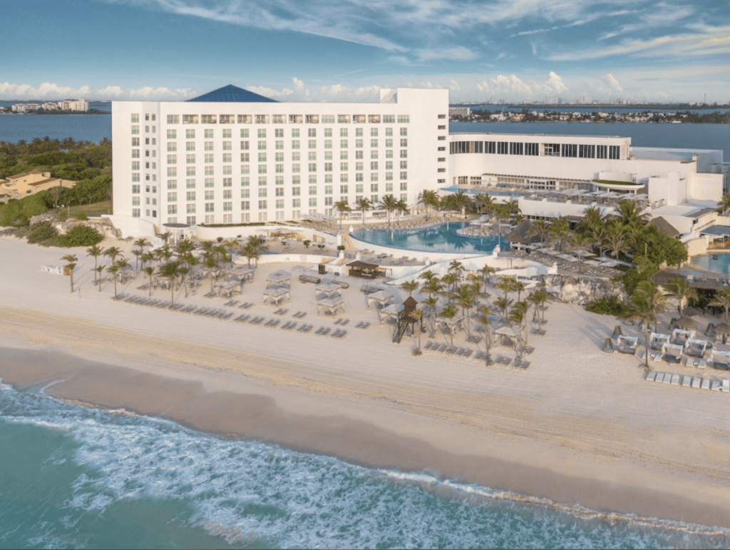 Aerial view of Le Blanc Spa Resort Cancun beachfront with white sand and lounge chairs