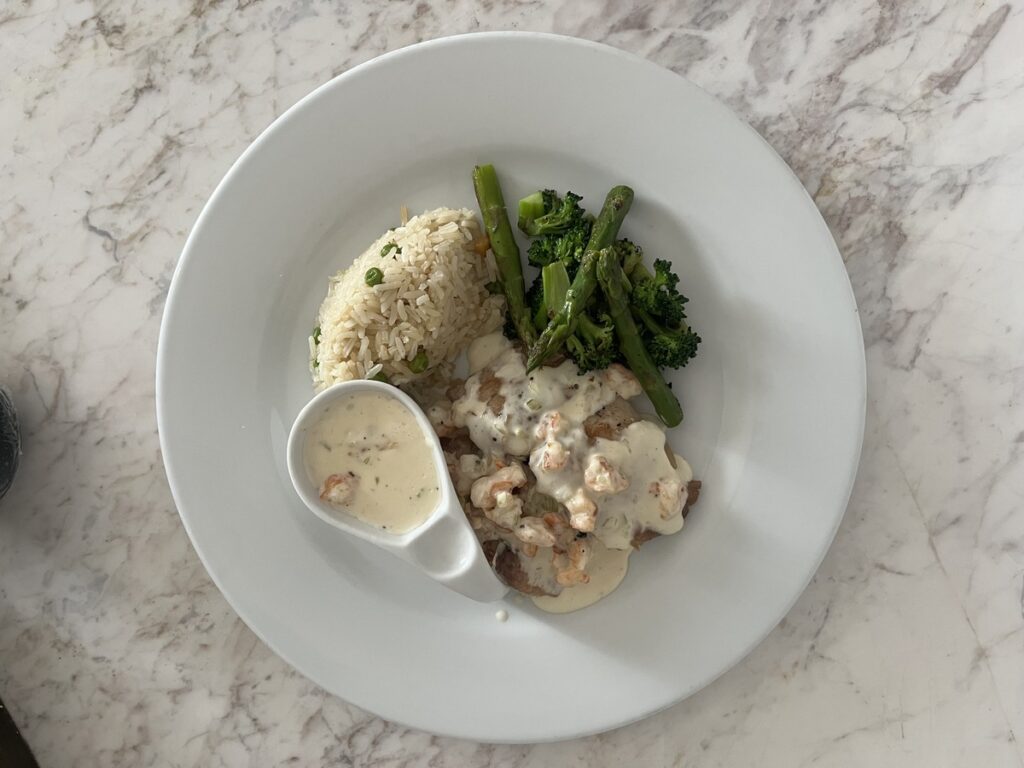 Plated seafood entrée with rice and vegetables at Marival Armony