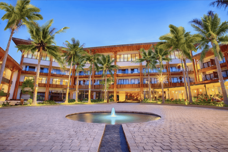 Resort entrance with fountain and palm trees at Armony Marival Resort & Spa